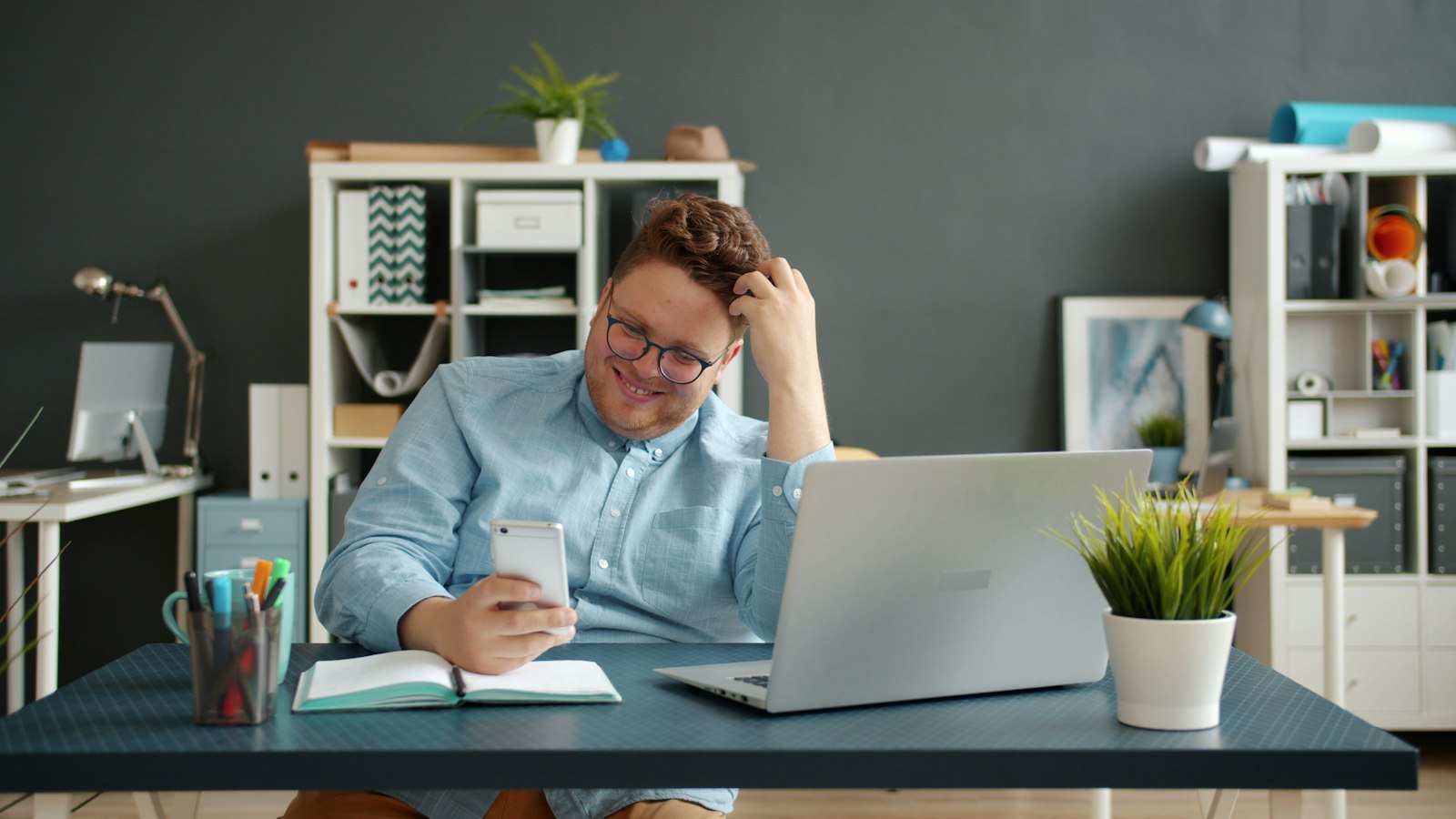 Business owner answering a customer on his phone at his desk